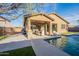 Stunning exterior view showcasing the covered patio, sparkling pool, and well-manicured backyard at 13568 N 144Th Dr, Surprise, AZ 85379