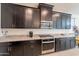 Kitchen featuring granite countertops, modern appliances, and dark cabinetry at 13568 N 144Th Dr, Surprise, AZ 85379
