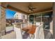 Covered outdoor dining area with a large table, seating for eight, and built-in grill at 13568 N 144Th Dr, Surprise, AZ 85379