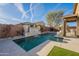 Serene pool area with a waterfall feature, stone accents, and manicured landscaping at 13568 N 144Th Dr, Surprise, AZ 85379