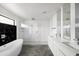 Luxurious bathroom featuring a soaking tub, glass-enclosed shower, and sleek vanity with modern fixtures at 14025 N 11Th Pl, Phoenix, AZ 85022