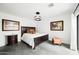 Stylish bedroom with a dark wood bed frame, unique lighting fixture, and sliding door access to the backyard at 14025 N 11Th Pl, Phoenix, AZ 85022