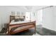 Bedroom with a wooden bed frame, concrete floors, modern lighting and a sliding barn door into the ensuite at 14025 N 11Th Pl, Phoenix, AZ 85022