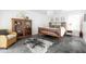 Cozy bedroom with a wood frame bed, woven armchair, stylish decor and lots of natural light at 14025 N 11Th Pl, Phoenix, AZ 85022