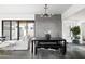 Modern dining area featuring a dark wood table and contemporary chandelier, with access to the back patio at 14025 N 11Th Pl, Phoenix, AZ 85022