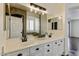 Elegant bathroom featuring a double vanity with white cabinetry and a decorative mirror at 14474 W Lexington Ave, Goodyear, AZ 85395