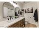 Bathroom featuring a dual sink vanity, framed mirrors, modern fixtures, and neutral color scheme at 14474 W Lexington Ave, Goodyear, AZ 85395