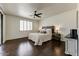 Serene bedroom featuring dark hardwood floors, a ceiling fan, and sliding glass doors at 14474 W Lexington Ave, Goodyear, AZ 85395