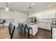 Bright kitchen featuring white cabinets, granite counters, stainless steel appliances, and a central island with seating at 14474 W Lexington Ave, Goodyear, AZ 85395
