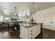 Kitchen island with granite counters, stainless steel dishwasher, sink, and connection to living spaces and backyard at 14474 W Lexington Ave, Goodyear, AZ 85395