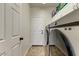 Efficient laundry room features a modern washer and dryer set with overhead cabinets at 14474 W Lexington Ave, Goodyear, AZ 85395