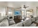 Spacious living room with a large gray sectional, ceiling fan, and sliding glass doors to an outdoor patio at 14474 W Lexington Ave, Goodyear, AZ 85395