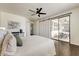 Inviting main bedroom featuring dark hardwood floors, a ceiling fan, and sliding glass doors at 14474 W Lexington Ave, Goodyear, AZ 85395