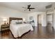 Spacious main bedroom featuring dark hardwood floors, a ceiling fan, and access to an en-suite bathroom at 14474 W Lexington Ave, Goodyear, AZ 85395