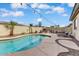 Sparkling pool with surrounding patio, fireplace, and ample lounging space at 14474 W Lexington Ave, Goodyear, AZ 85395