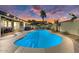 Beautiful backyard pool with outdoor kitchen, pergola, and string lights at sunset at 14474 W Lexington Ave, Goodyear, AZ 85395