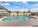 Inviting backyard pool with professional landscaping, string lights, and outdoor fireplace at 14474 W Lexington Ave, Goodyear, AZ 85395