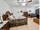 A spacious bedroom featuring a wooden bed frame, ceiling fan, and carpet flooring at 1455 W Posada Ave, Mesa, AZ 85202