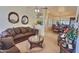 Open-concept living room showcasing brown sofas, decorative mirrors, and a glimpse into the dining area at 1455 W Posada Ave, Mesa, AZ 85202