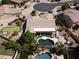 Aerial view of a house with a dark pool, putting green, lush landscaping, and outdoor living at 1544 N Rico Cir, Mesa, AZ 85213