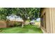 Backyard with a mature shade tree and a charming playhouse on artificial turf at 1544 N Rico Cir, Mesa, AZ 85213