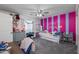 Stylish bedroom highlighting pink accent wall, personal touches, and soft natural lighting at 15802 N 50Th Dr, Glendale, AZ 85306