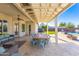 Relaxing covered patio with a large dining table, comfortable seating, and views of the beautiful backyard at 15802 N 50Th Dr, Glendale, AZ 85306