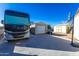 Long driveway featuring basketball hoop, RV parking, and storage sheds at 15802 N 50Th Dr, Glendale, AZ 85306