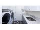 Well-equipped laundry room with modern washer and dryer, and bright granite countertop at 15802 N 50Th Dr, Glendale, AZ 85306