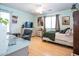 Bright bedroom featuring wood floors, ceiling fan, dresser with TV, and a cozy bed with decorative pillows at 16626 W Baden Ave, Goodyear, AZ 85338