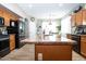 Kitchen with wood cabinets, granite countertops, stainless steel appliances, and a view to the dining area at 16626 W Baden Ave, Goodyear, AZ 85338