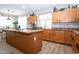 Spacious kitchen features wood cabinets, granite countertops, large island and stainless steel appliances at 16626 W Baden Ave, Goodyear, AZ 85338