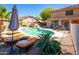 Inviting pool area with lounge chairs, patio table, and well-manicured landscaping at 16626 W Baden Ave, Goodyear, AZ 85338