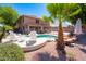 Outdoor view of the pool area with lounge chairs, palm trees, and a two-story home at 16626 W Baden Ave, Goodyear, AZ 85338