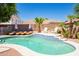 Sparkling pool with lounge chairs, lush landscaping, and palm trees in a private backyard at 16626 W Baden Ave, Goodyear, AZ 85338