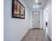Inviting hallway showcasing wood-look tile flooring, complemented by neutral wall paint, artwork and white doors at 16868 W Earll Dr, Goodyear, AZ 85395