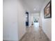 Bright hallway featuring wood-look tile flooring, leading to the living area, enhanced by recessed lighting at 16868 W Earll Dr, Goodyear, AZ 85395