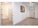 Well-lit hallway with wood-look flooring, offering access to a powder room and the front door at 16868 W Earll Dr, Goodyear, AZ 85395