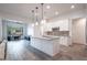 Open-concept kitchen with white cabinetry, granite countertops, stainless steel appliances and a central island at 16868 W Earll Dr, Goodyear, AZ 85395