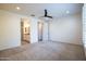 Bright bedroom with neutral carpet leading to the bathroom and a large, open space at 16868 W Earll Dr, Goodyear, AZ 85395