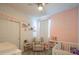 Bedroom with pink accent wall, crib, chair, and whimsical decorations at 17342 W Patrick Ln, Surprise, AZ 85387