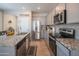 Modern kitchen featuring stainless steel appliances, granite countertops, and gray cabinets for a sleek design at 17342 W Patrick Ln, Surprise, AZ 85387