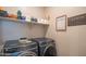 Laundry room with front-load washer and dryer, shelving, and laundry-themed decor at 17342 W Patrick Ln, Surprise, AZ 85387