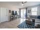 Cozy living room features a gray sectional sofa, a modern media console, and natural light from sliding glass doors at 17342 W Patrick Ln, Surprise, AZ 85387