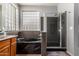 Modern bathroom featuring a standalone soaking tub, a glass block window, and a tiled glass shower enclosure at 1917 S Rock Ct, Gilbert, AZ 85295