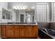 Bathroom featuring a double sink vanity, a large mirror, a black soaking tub, and a glass block window at 1917 S Rock Ct, Gilbert, AZ 85295