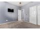 This carpeted bedroom features neutral walls, a ceiling fan, and a closet for ample storage at 1917 S Rock Ct, Gilbert, AZ 85295
