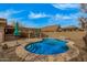 Sparkling pool with rock feature and umbrellas, situated near the cozy covered patio and kitchen for outdoor enjoyment at 1917 S Rock Ct, Gilbert, AZ 85295