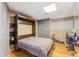 Bedroom featuring a Murphy bed, a grey wardrobe, a side table, and a workspace with desk and chair at 2260 E Palmaire Ave, Phoenix, AZ 85020