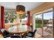 Cozy dining area with modern lighting, a glass top table, and sliding glass doors leading to the backyard at 2260 E Palmaire Ave, Phoenix, AZ 85020